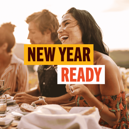 Words New Year Ready with lady laughing in the background at a table of food with friends 